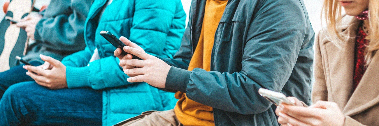 A group of people using their cellphones to type.